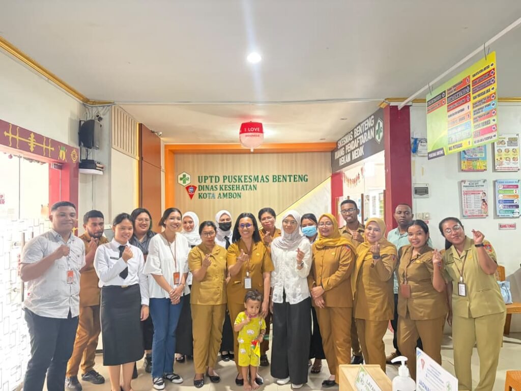 Staff and visitors pose under the UPTD Puskesmas Benteng sign