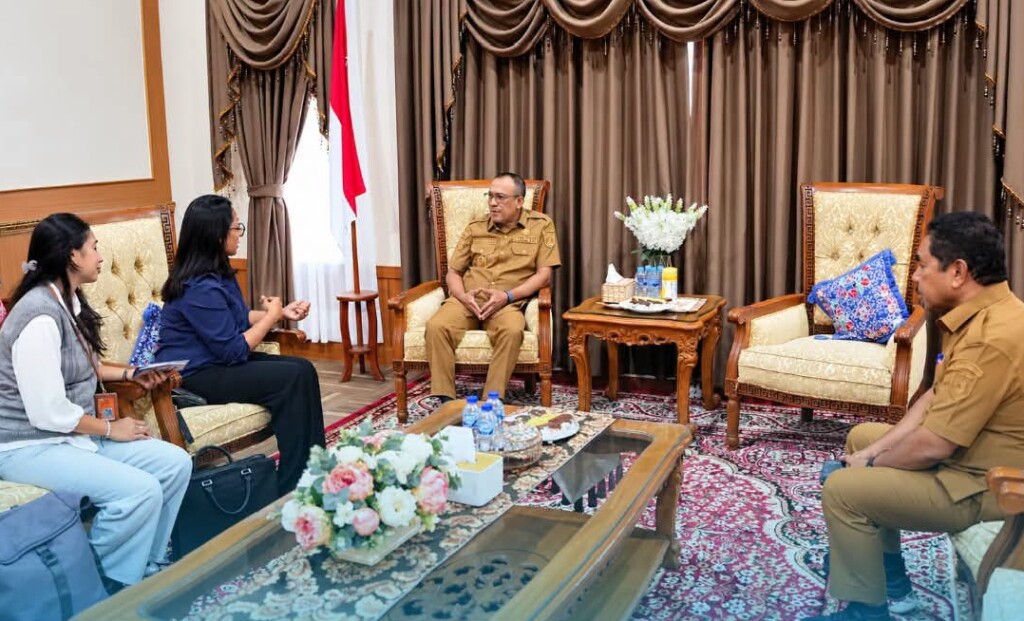A formal meeting in Masohi, with two officials in brown uniforms and two visitors seated around a coffee table