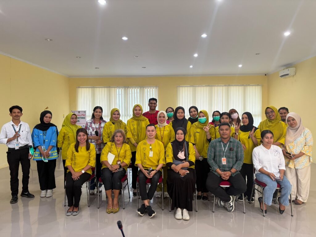 Staff and visitors pose in a hall, many of them in yellow shirts